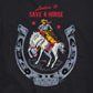 Ladies long sleeved crop t-shirt in black cotton. Front graphic features a vintage-style illustrtion of a cowboy riding a bucking bronco. Text says Lookin' to save a Horse.