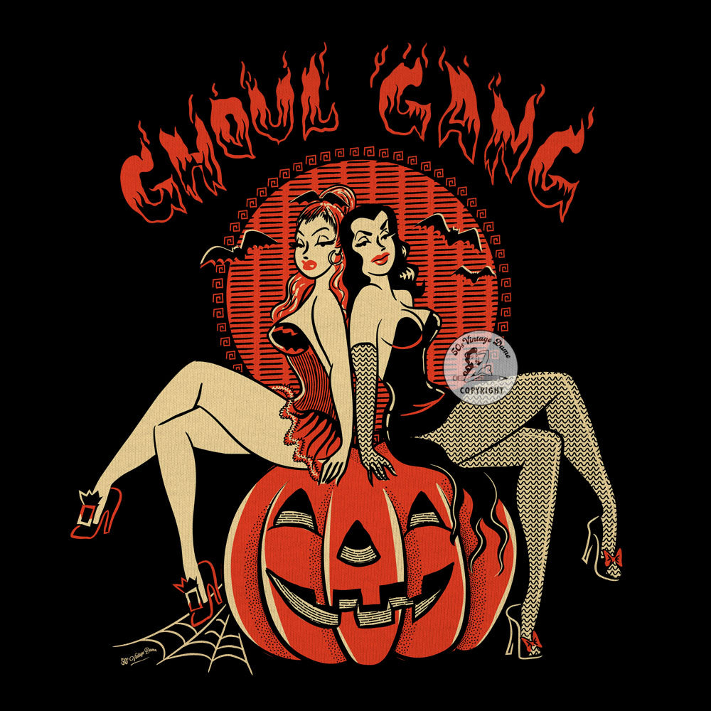 Detail of graphic on Ladies V-neck black Halloween T-shirt featuring two pinup witches sitting on a giant pumpkin. Text say "Ghoul Gang"