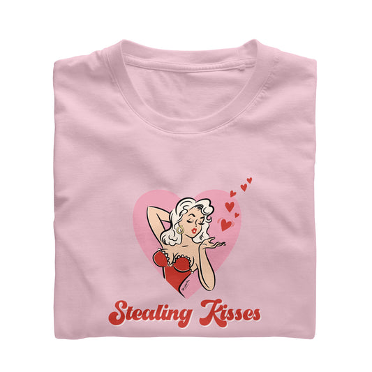 Tee shirt with vintage illustration of a pinup girl inside a heart blowing kisses. caption says Stealing Kisses.